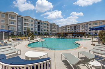 Resort-inspired pool with water features, tanning shelf, & sun deck